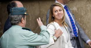 Cospedal sonriente, a la salida del juicio que perdió, saludada por un agente de la Guardia Civil
