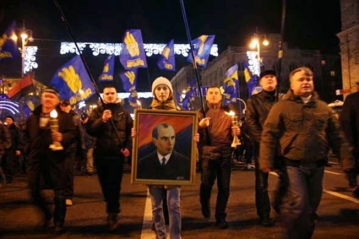 Manifestantes con la bandera de Svoboda y una imagen de Stepán Bandera